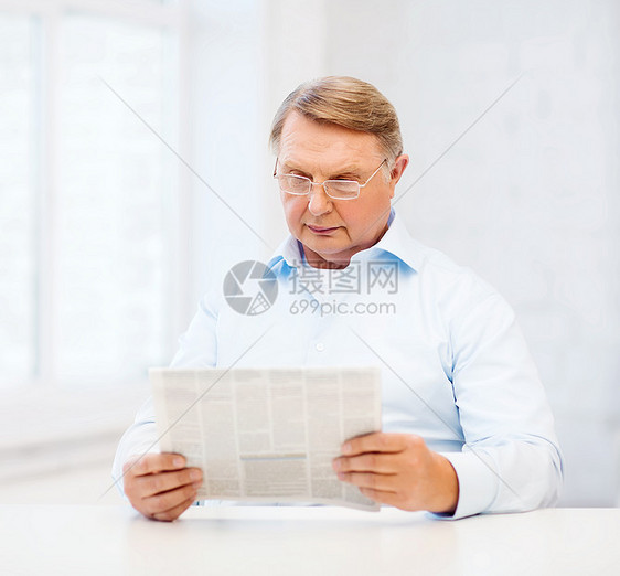 家庭阅读报纸上的老人微笑眼镜祖父时间读者闲暇成人幸福老年男性图片