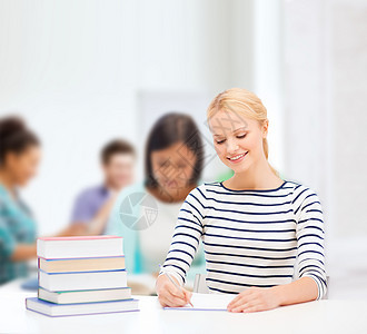 在大学学习的有微笑的妇女导师班级考试学校职场知识女孩快乐笔记本写作图片