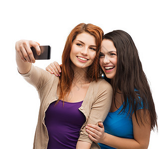 两个带着智能手机的笑笑青少年拍照技术朋友们互联网图画相机幸福女性友谊照片图片