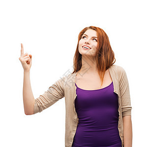 笑笑的少女指着她的手指公告衣服白色指挥采摘广告注意力青少年学生幸福图片