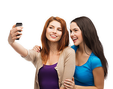 两个带着智能手机的笑笑青少年乐趣闺蜜朋友们技术女性细胞幸福青年娱乐相机图片