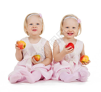 两个完全相同的双胞胎女孩玩苹果游戏童年乐趣活力婴儿营养家庭姐姐女儿们兄弟姐妹女孩们图片