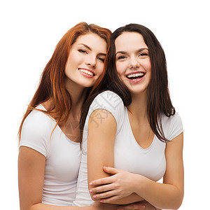两个笑着女孩 穿着白色T恤拥抱友谊寒意乐趣队友幸福女性闺蜜成年人青少年朋友们图片