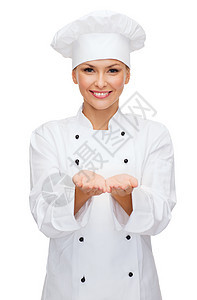 微笑的女厨师拿着手握着东西女性面包帽子职业助手餐厅美食成人管理人员工作图片