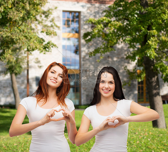两个微笑的女孩 用双手露出心成年人手势朋友们情感幸福帮助乐趣闺蜜机构友谊图片