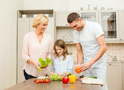 幸福的家庭在厨房做晚餐烹饪蔬菜食物桌子午餐男人喜悦早餐母亲父母图片