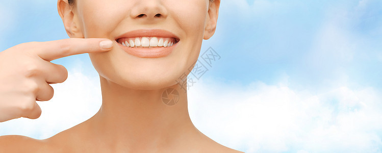 指着牙齿的美丽的女人女性微笑呼吸牙科保健女孩天空卫生手指矫正图片