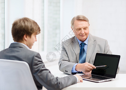 带膝上型计算机的老年男子和青年男子雇主讨论人士公司微笑笔记本合伙会议男人电脑图片