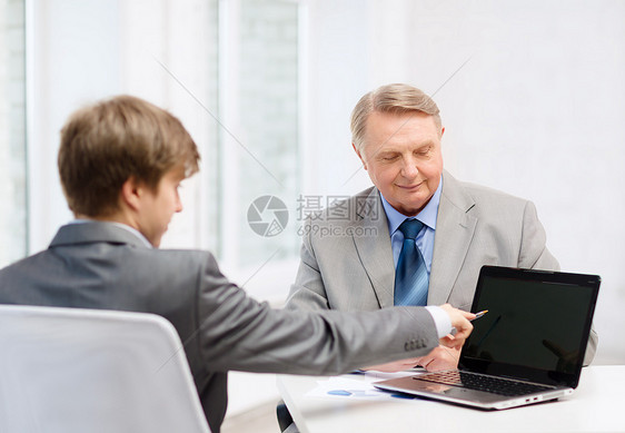 带膝上型计算机的老年男子和青年男子微笑公司成人讨论场景人士电脑团体技术老板图片