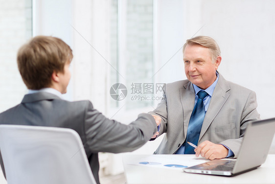 年长男子和年轻男子在办公室握手员工工人雇主合作欢呼合伙笔记本人士男人顾客图片