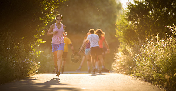年轻女子在阳光明媚的夏日夜晚户外奔跑公园女士慢跑闲暇越野运动员火车背景活力运动图片