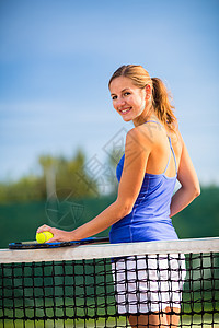 在法庭上一个漂亮的年轻网球运动员的肖像女性冠军优胜者娱乐火车快乐微笑运动成功蓝色图片