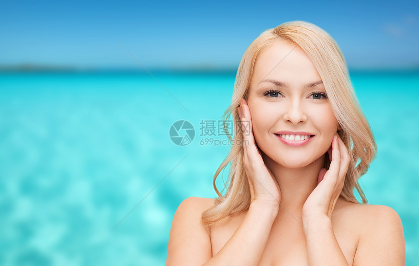 妇女触摸其脸部皮肤蓝色金发女郎保湿治疗女性清洁女孩微笑假期海滩图片