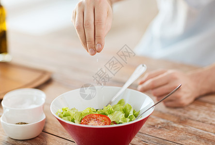 雄手紧紧地在碗里吃沙拉蔬菜勺子季节午餐饮食行动木板香料厨房男人图片