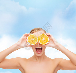 以橙片为奇异的年轻女子天空蓝色卫生乐趣饮食保健女孩橙子女性水果图片