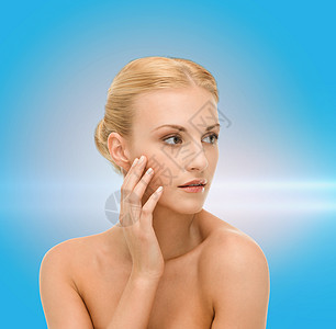 美丽的女人触摸她的脸皮治疗蓝色容貌保湿激光清洁女孩福利护理皮肤图片