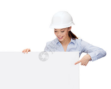 戴头盔的女商务人士用手指对着板商务建筑师老板女士建设者微笑女性工程师木板工作图片