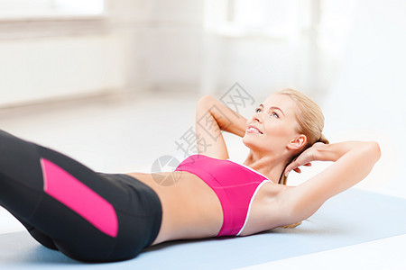 在地板上做运动的女运动员锻炼有氧运动训练地面腹肌女性运动装房间培训师女孩图片