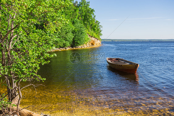 河岸上的木船边缘场景乡村航海森林反射蓝色河流木头旅行图片