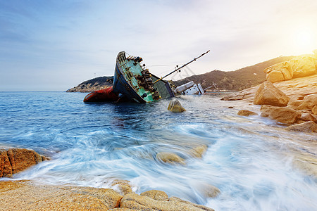 海难和海景日落沉船支撑货物海岸线钓鱼商品岩石血管海滩海岸图片