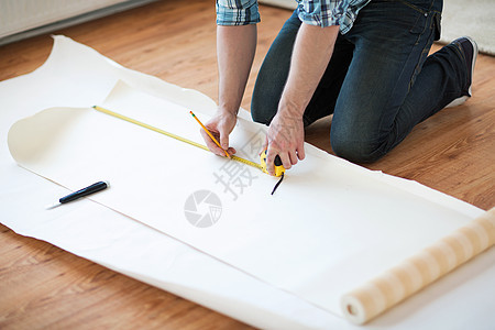 男性用手紧紧的手 测量壁纸仪表男性铅笔装修公寓装潢工具材料改造成人图片