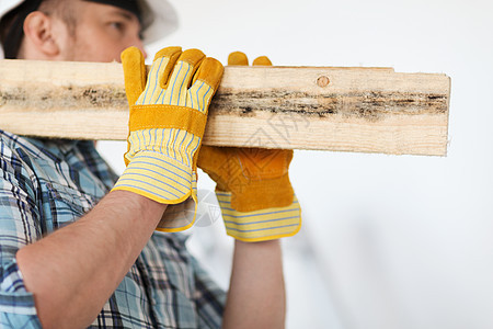 身戴手套 手戴木板的男性近身男子承包商维修安全帽木头材料男人工作建设者头盔齿轮图片