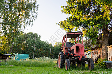 夏季草原的红色旧拖拉机图片