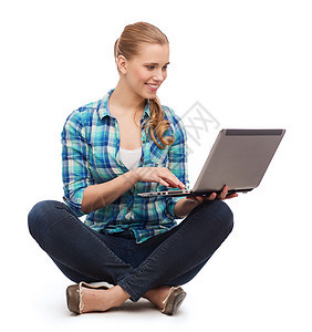 带着笔记本电脑坐在地板上微笑的女人成人女性学生青年教育幸福女孩衣服青少年姿势图片