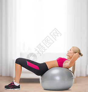 带着健身球的微笑着的妇女女性运动教练身体运动装讲师说谎长椅腹肌锻炼图片