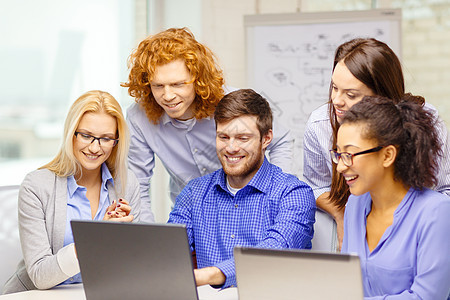 配备办公室膝上型计算机的微笑小组上网头脑简报电脑团体男人伙伴拉丁合作讨论图片