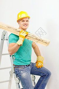 身戴头盔 带木板的手工工人职业维修材料安全梯子安全帽建设者房子男性承包商图片