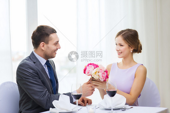 男人笑着在餐厅送花束庆典男朋友生日妻子男性牡丹展示纪念日玫瑰眼镜图片