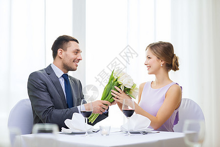 男人笑着在餐厅送花束订婚女朋友展示丈夫家庭妻子庆典夫妻纪念日男性图片