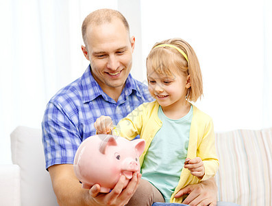 快乐的父亲和女儿 大小猪银行银行房间男人男性现金微笑财富家庭财政孩子图片