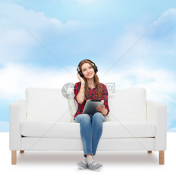 用耳机和平板电脑坐在沙发上的女孩天空音乐播放器长椅幸福播客打碟机药片闲暇立体声收音机图片