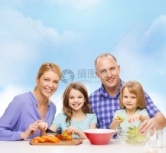 有两个孩子在家做晚饭的幸福家庭男人童年食物女儿厨房父母女士蓝色烹饪教学图片