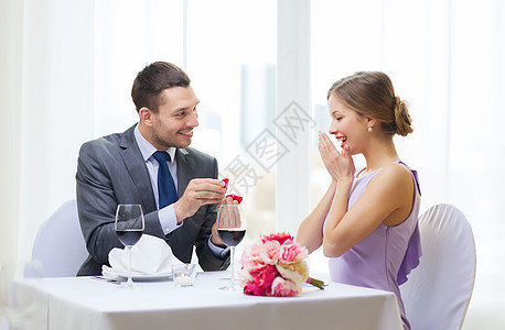 男人向在餐厅的女朋友求婚的男人花束订婚花朵钻石幸福展示庆典戒指婚礼家庭图片