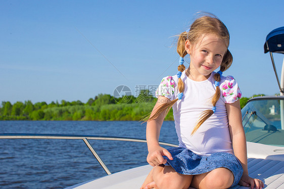 小女孩在豪华游艇上航行假期水手女孩导航微笑娱乐蓝色运动海洋海浪图片