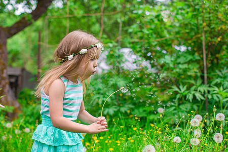 可爱的小女孩吹响花棚 在花园乐趣头发花朵编织喜悦女孩森林手臂脸颊草地图片