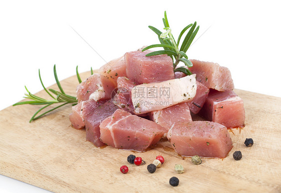 厨房餐板上的生肉片 白色背景的肌肉牛肉迷迭香草本植物立方体食物横截面红肉鱼片牛扒图片
