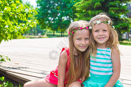 在温暖的夏日 快乐可爱的小姑娘们头发乐趣压痛叶子衬套女孩们喜悦孩子幸福花园图片