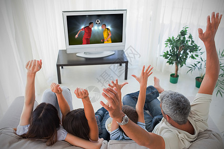 家庭欢乐和在家看世界杯团结亲密感游戏头发孩子母亲娱乐性欢呼电视儿子图片