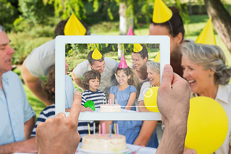 手握平板电脑的复合图像c父母幸福老年闲暇成人草地男性兄弟公园笑声图片
