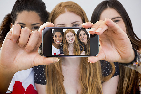 手持智能手机显示的复合图象享受女性房子技术女孩头发公寓金发女郎快乐棕色图片