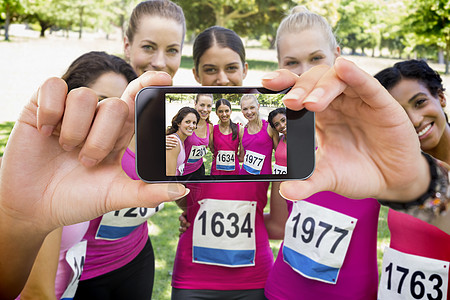手持智能手机显示的复合图象体育屏幕数字健康展示生活方式运动女性志愿者女士图片