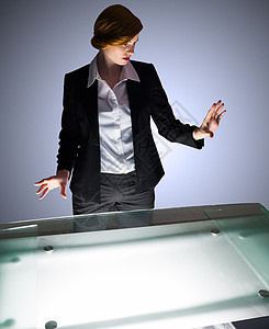 红头女商务人士站在一个办公桌旁和看管着商业红发人士衬衫公司商务职业女士桌子手势图片