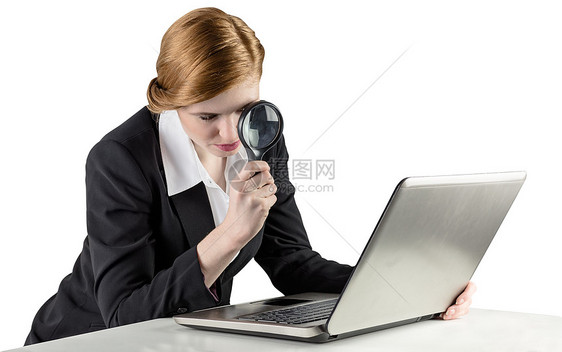 使用笔记本电脑的红头女商务人士放大镜好奇心人士搜索女性专注女士职业商务调查图片