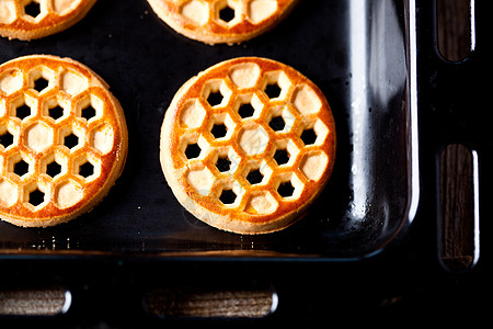 蜂窝烤箱烘烤纸上的蜂蜜饼干巧克力厨房小吃食物黑色烤箱白色面包平底锅烹饪背景