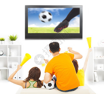 年轻球迷在看足球赛时大喊大叫合作控制男性家庭手臂锦标赛啤酒女性电视闲暇图片