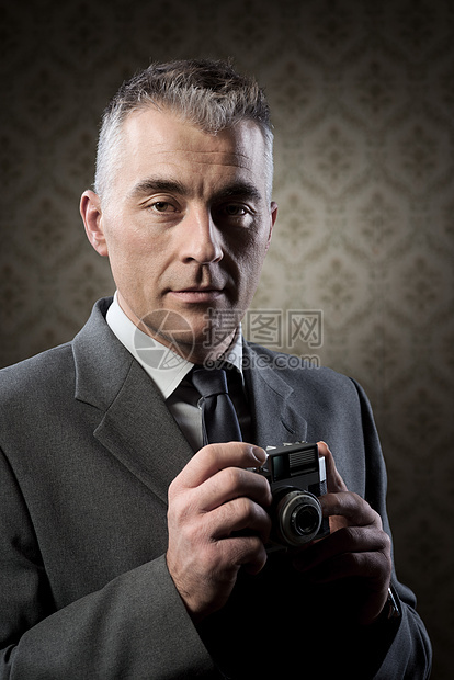 配有旧相机的摄影师美容专注复古爱好摄影器材工作室职业男性记者图片